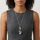Woman wearing a gray sleeveless top with a Southwest Horse Head Turquoise Locket & Charms Necklace