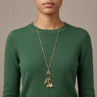 Person wearing a green sweater with a Charm Pendant Necklace Compass Heart Lion
