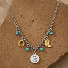 Necklace with charms including a horse head, horseshoe, and cowboy boot on a brown stone background