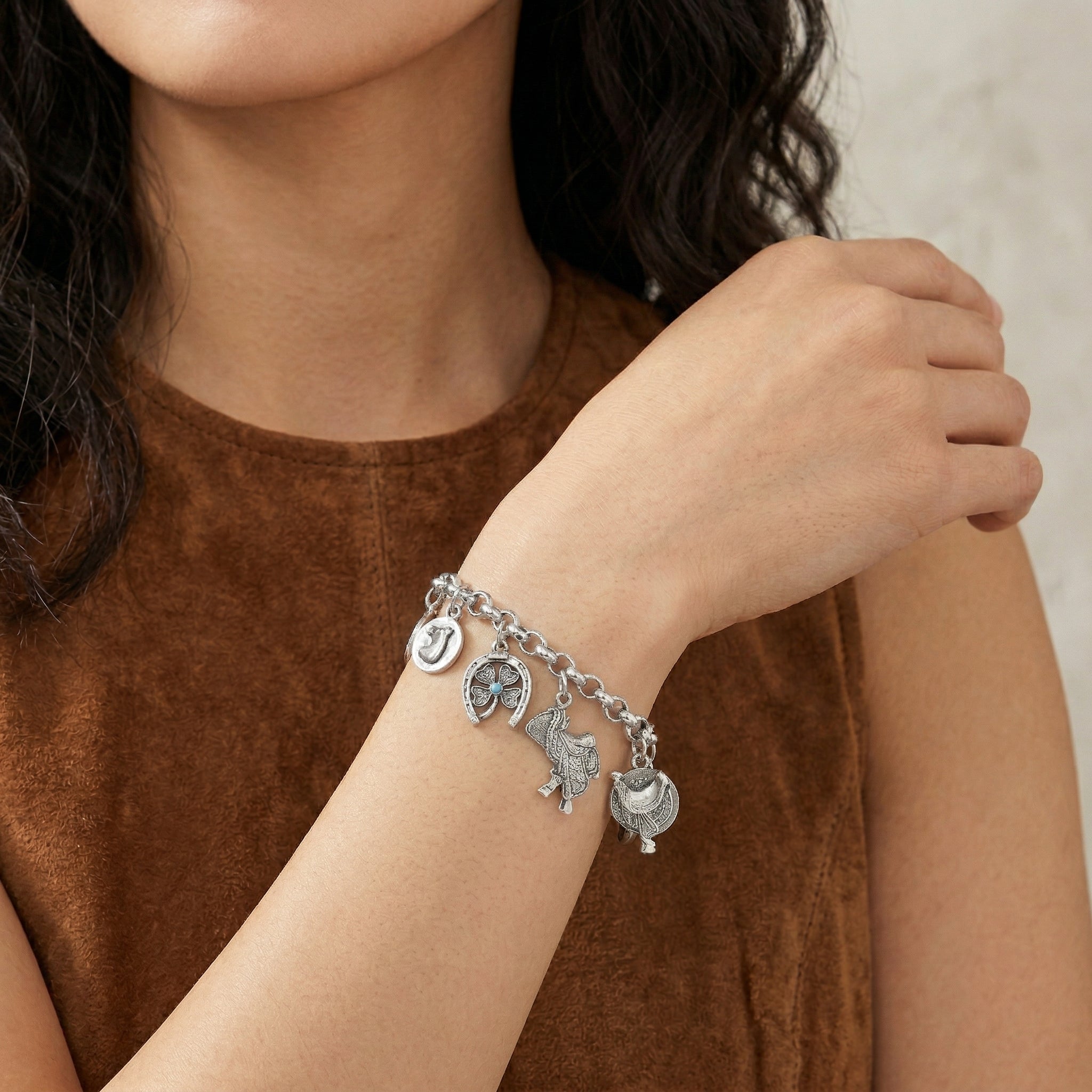 Southwest Equestrian Multi Charm Link Bracelet on a person's wrist with a neutral background