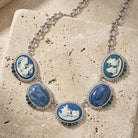 Necklace with blue and white cameo pendants on a textured stone surface