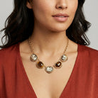 Roman Chariots Gala Cameo & Tigers Eye Stones Necklace worn by a woman in a red dress