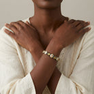Woman in a white outfit wearing an Olivine & Multicolored Floral Stone Stretch Bracelet 