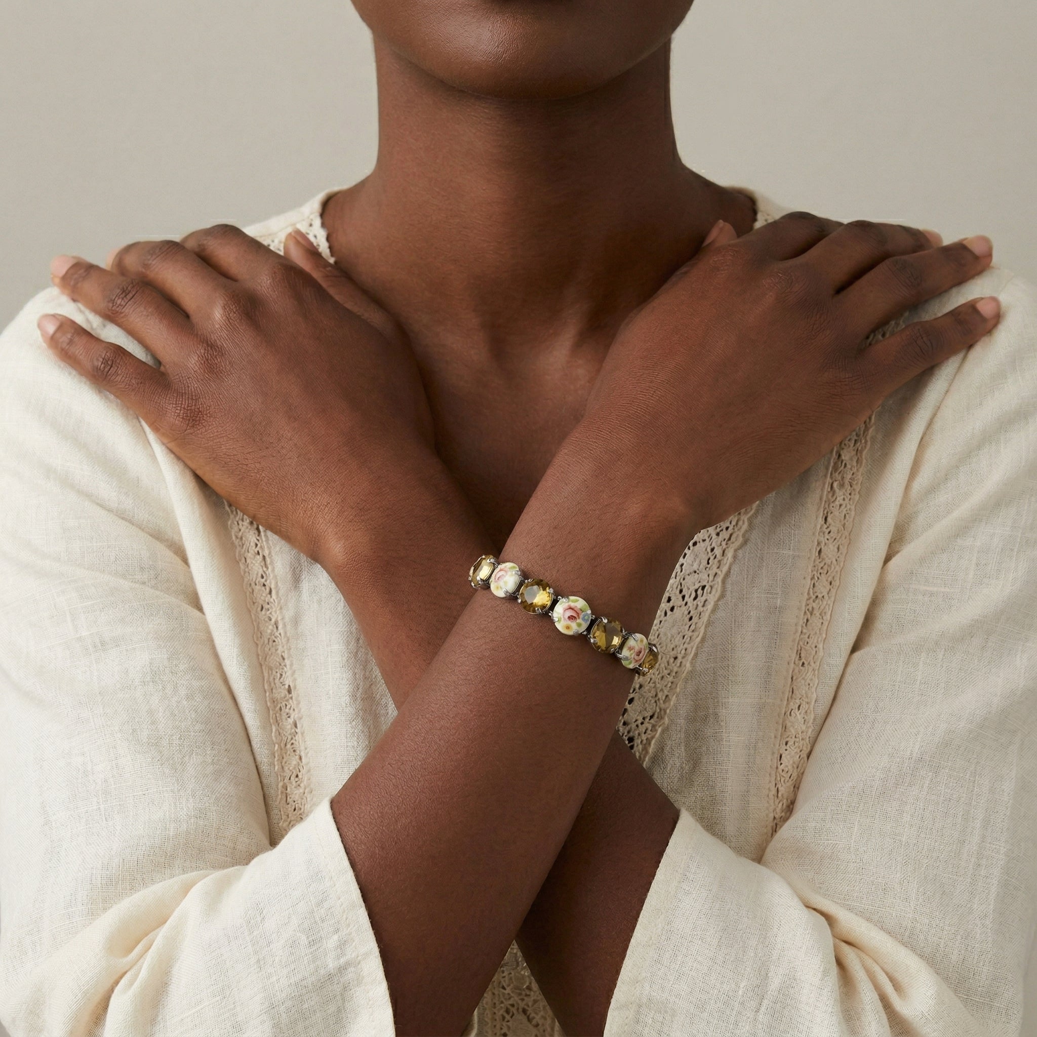 Woman in a white outfit wearing an Olivine & Multicolored Floral Stone Stretch Bracelet 