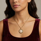 Woman wearing a gold tone Stitch Pattern Pink Rose Pendant Necklace
