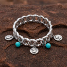 Horse Head Charms Turquoise Bead Stretch Bracelet on a textured brown stone surface