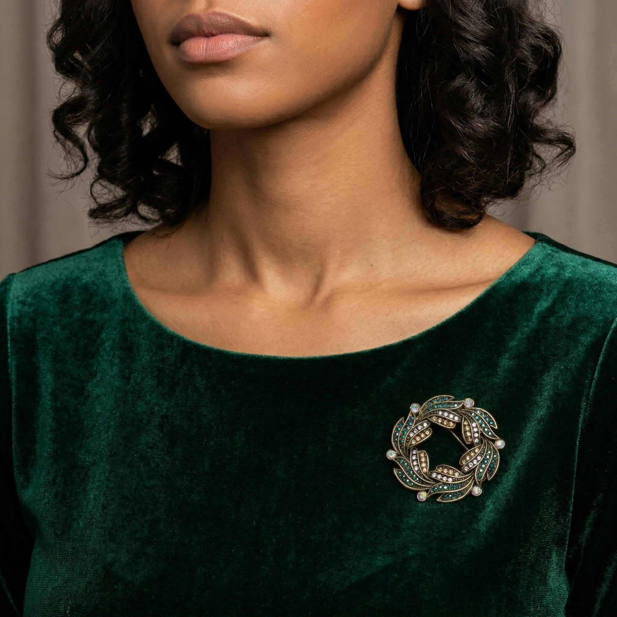 Woman wearing a green velvet dress with Peacock Plumage Blue Iridescent AB Glass Stone Wreath Brooch
