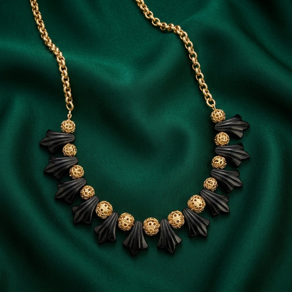 Black Tulip Flower Filigree Puff Bead Necklace on a green fabric background