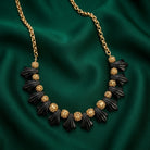 Black Tulip Flower Filigree Puff Bead Necklace on a green fabric background