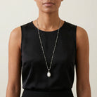 White Gemstone Bead Pendant Necklace worn by a woman in a black sleeveless top