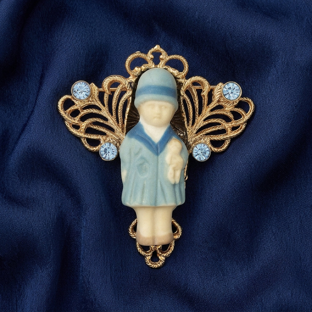Blue crystal Winged Filigree Porcelain Child With Doll Pin on a dark blue fabric background