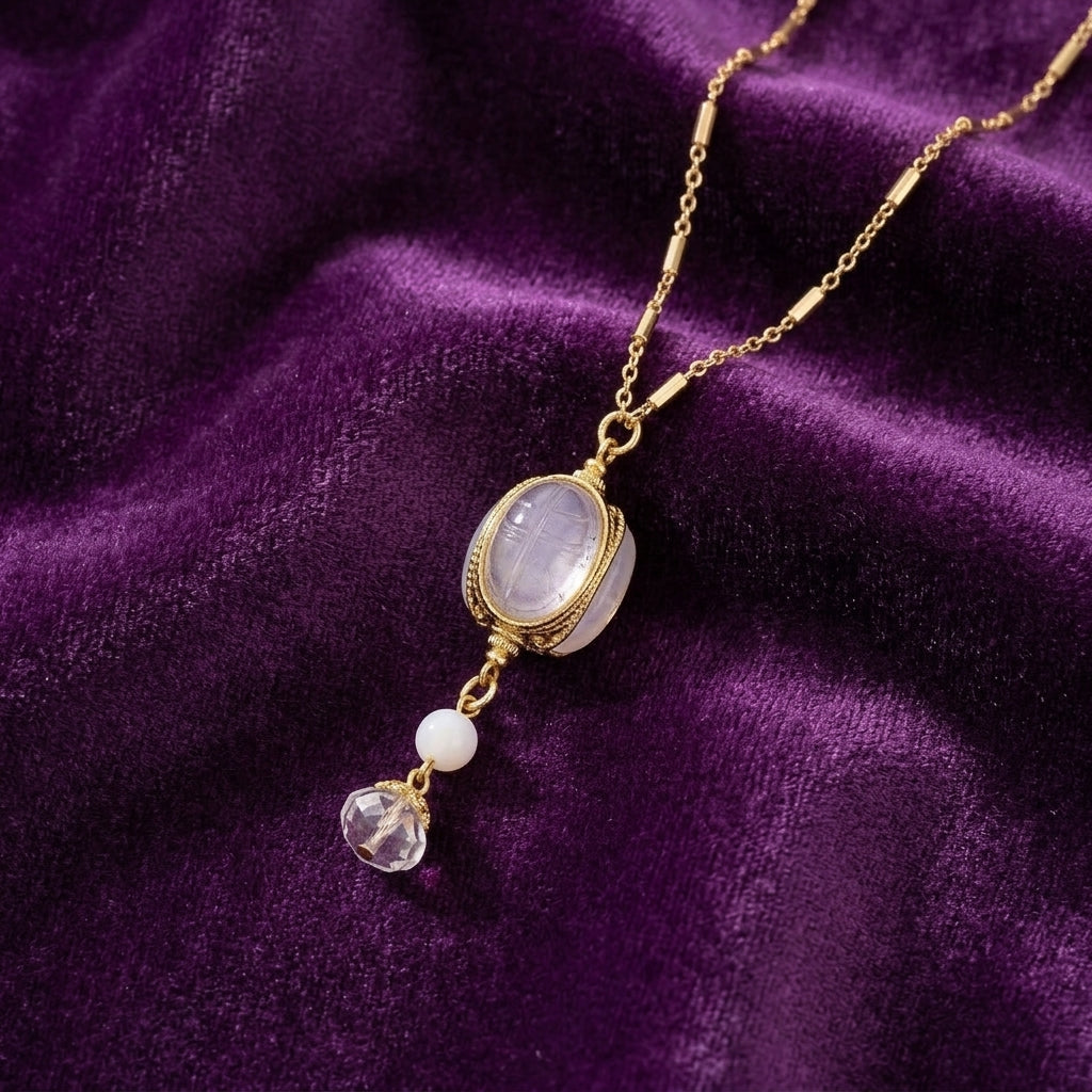 White Crystal Opal Stone 3 Sided Spinner Drop Necklace on a purple fabric background