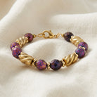 Purple Fire Polished Glass Beaded Bracelet on a white linen fabric