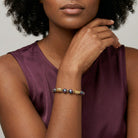 Woman in a purple top wearing a Purple Fire Polished Glass Beaded Bracelet