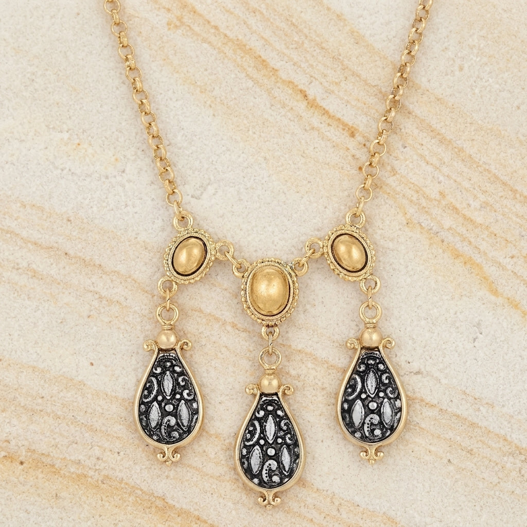 Antioch Teardrop Gold Stone Necklace on a beige marble background
