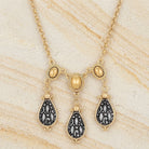 Antioch Teardrop Gold Stone Necklace on a beige marble background