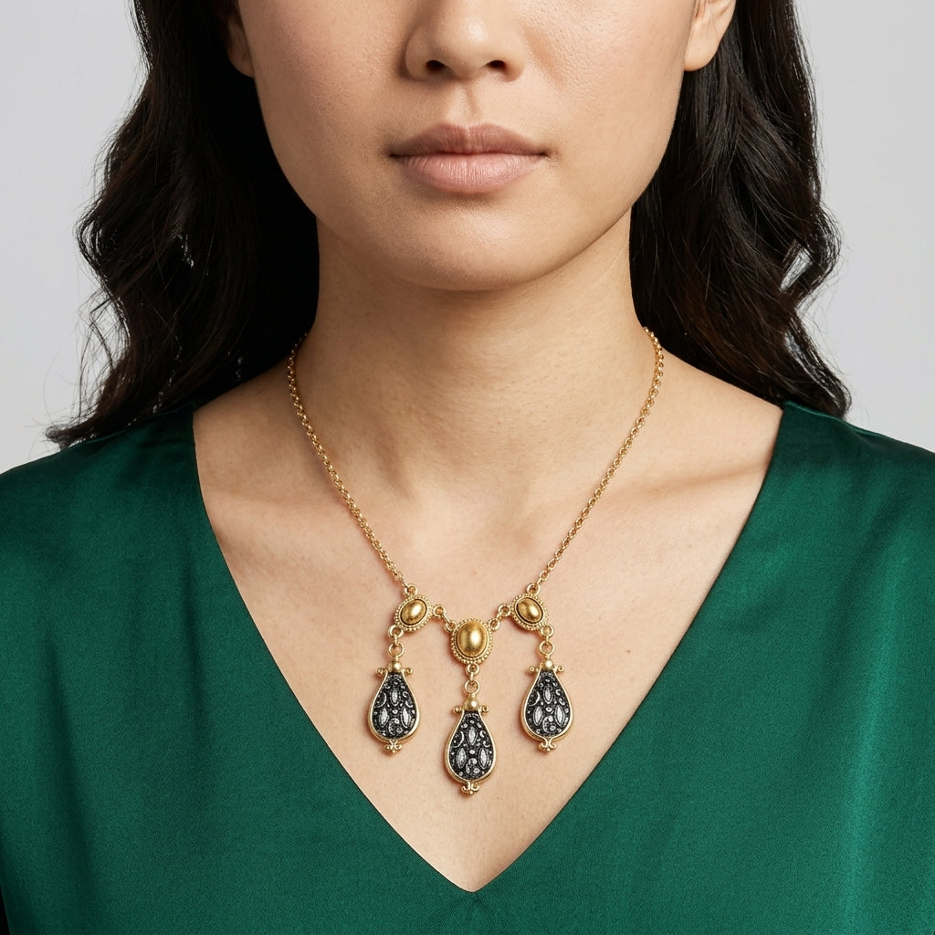 Woman wearing a Antioch Teardrop Gold Stone Necklace with a green dress