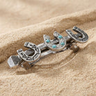 Triple Lucky Horseshoe Turquoise European Crystal Hair Barrette resting on a sandy stone surface
