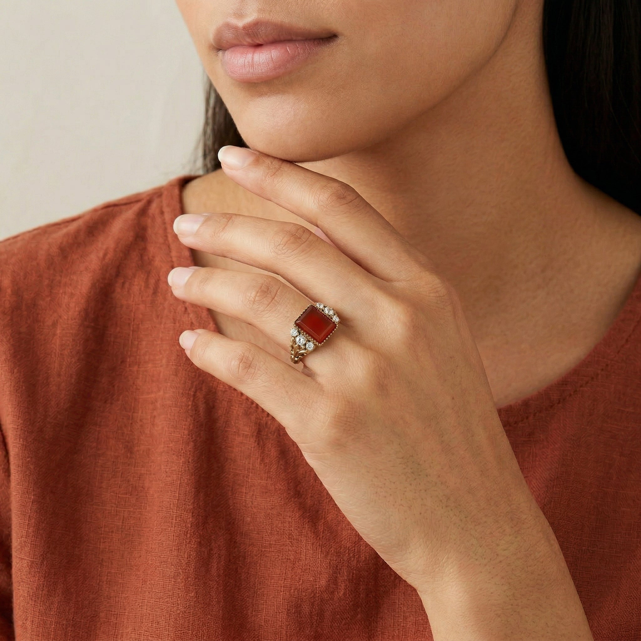 Close-up of a person wearing a Carnelian Gemstone Crystal Accent Ring