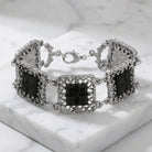 Deco Filigree Square Glass Stone Bracelet resting on white marble surface