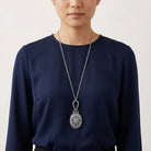 Person wearing a long Deco Floral Blue Enamel Sapphire Crystal Mirror Pendant Necklace