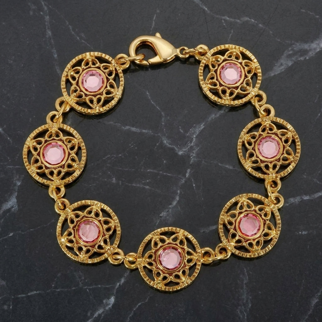 Gold tone Star Disk Channel Crystal Link Bracelet on a dark marble surface