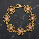 Gold tone Star Disk Channel Crystal Link Bracelet on a dark marble surface