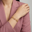 Woman in a pink blazer wearing a Star Disk Channel Crystal Link Bracelet