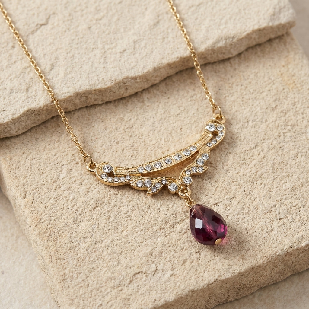 Cheshire Crystal Teardrop Collar Pendant Necklace resting on beige stone
