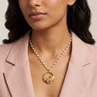 Woman wearing a pink blazer showcasing our Cat & Flowers Faux Pearl Pendant Necklace 