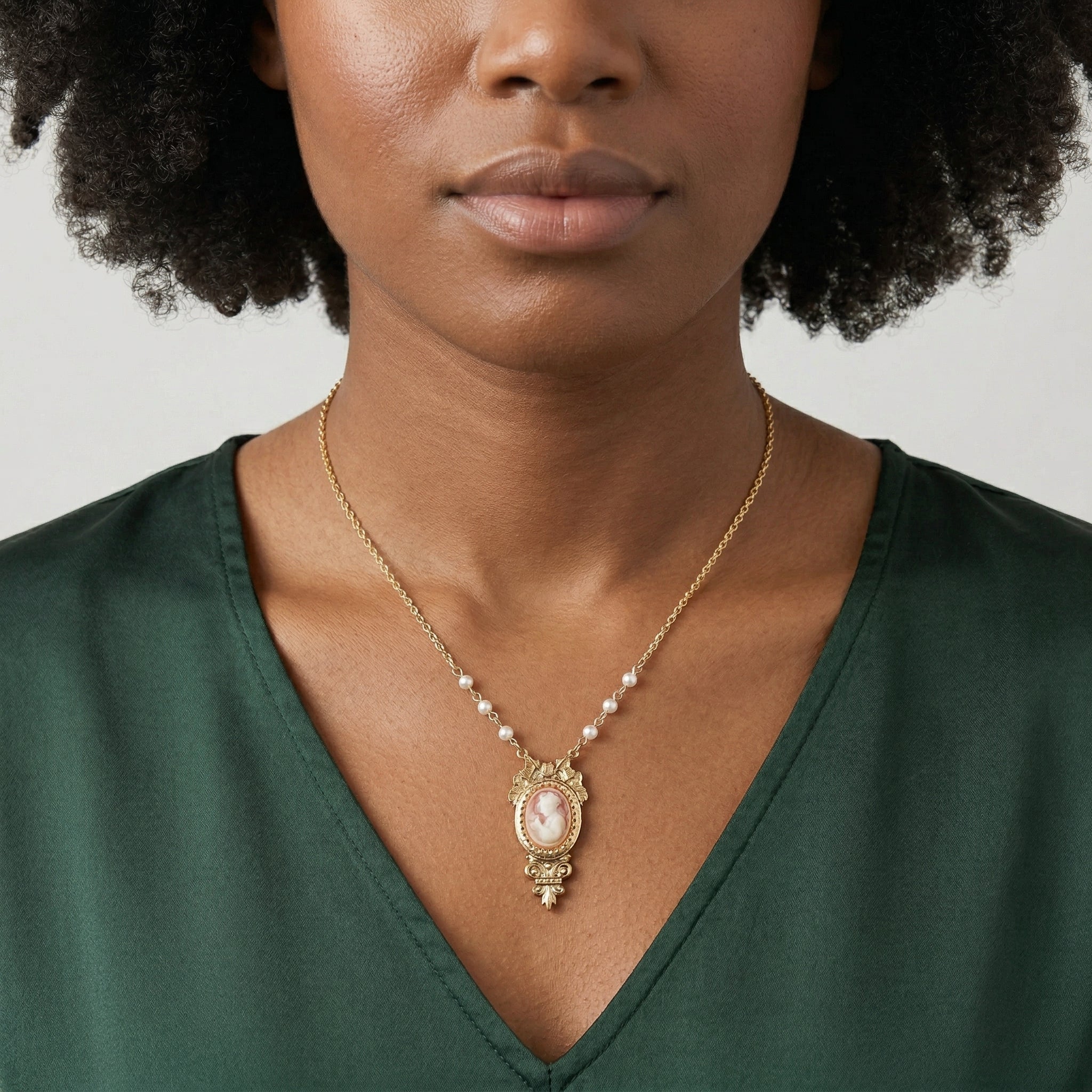 Victorian Reflections Carnelian & Ivory Cameo Faux Pearl Accent Necklace worn by a woman with a green outfit