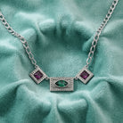 Vivida Multi Austrian Crystal Drop Necklace on a teal fabric surface