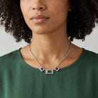 Vivida Multi Austrian Crystal Drop Necklace worn by a woman in a dark green top 
