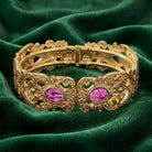 Gold tone Vienna Rose Pink European Crystal Hinge Cuff Bracelet resting on dark green fabric