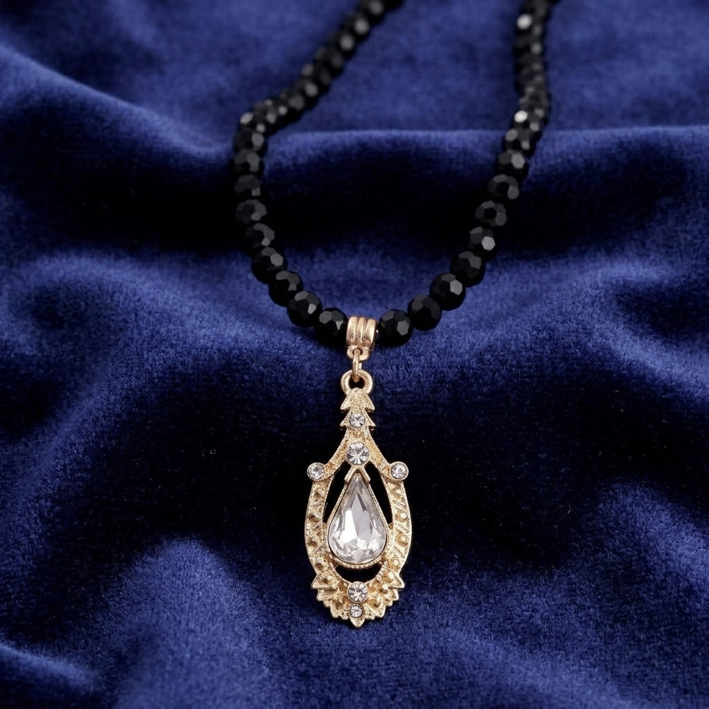 Minuit Black Glass Strand Bead Crystal Pendant Necklace on a dark blue fabric