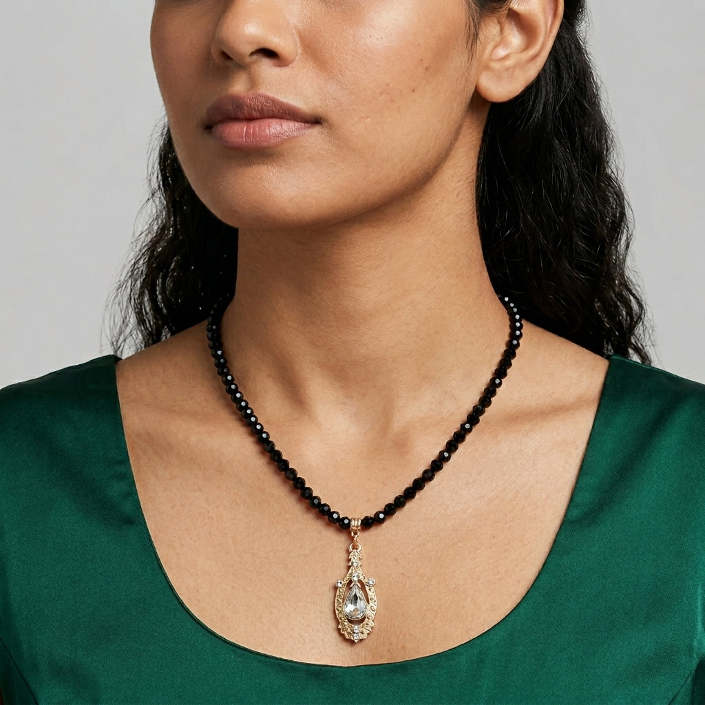 Woman in a green top wearing a Minuit Black Glass Strand Bead Crystal Pendant Necklace