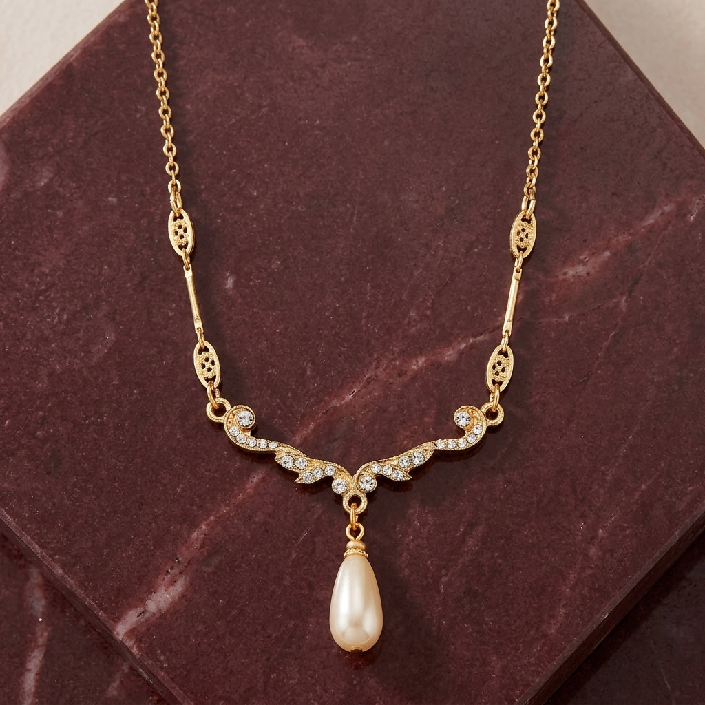Edwardian Teardrop Faux Pearl Crystal Necklace 16" + 3" Extender displayed on a dark reddish-brown stone surface.