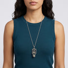 Woman wearing a silver tone pewter hourglass pendant necklace with functional sand inside