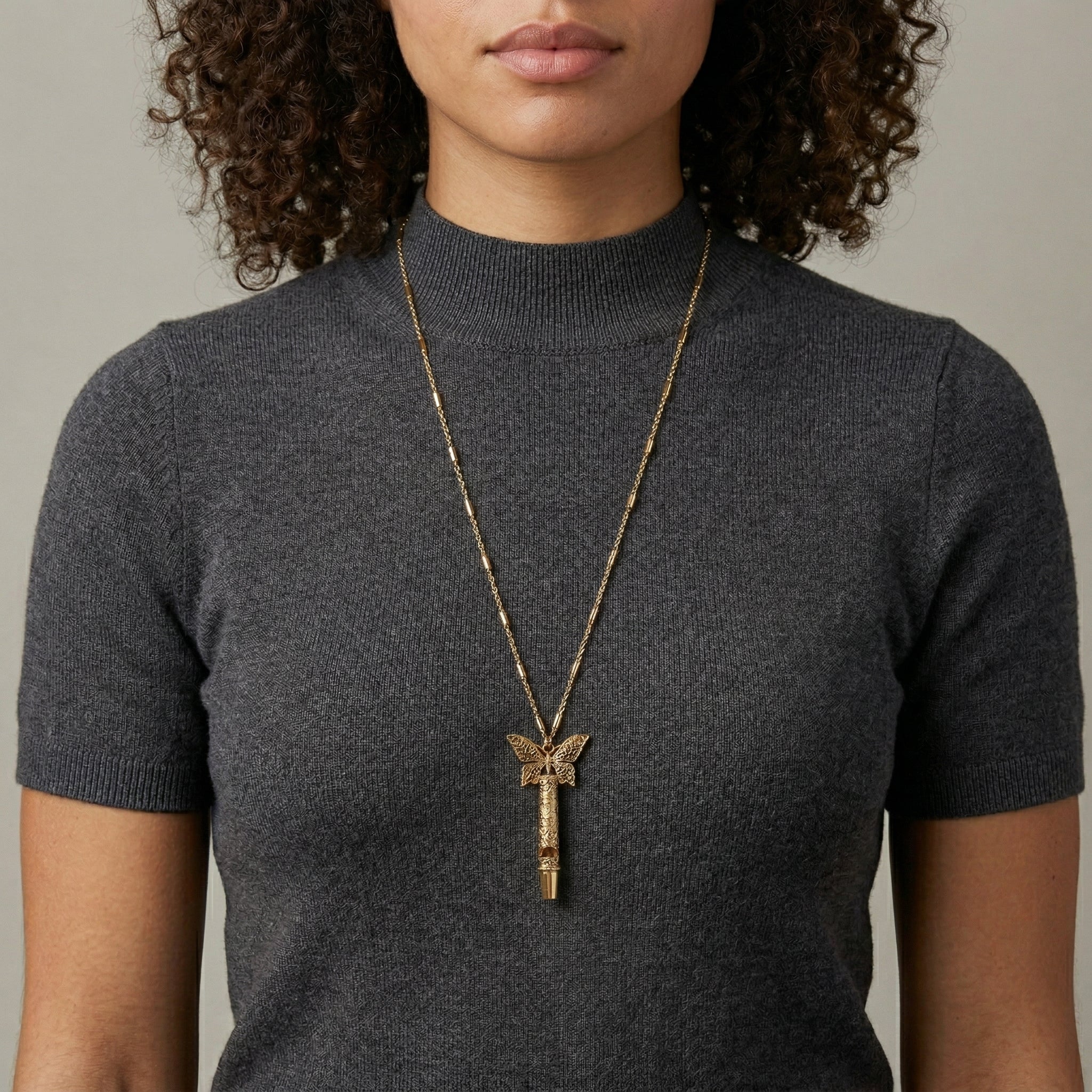 Person wearing a long Gold Filigree Whistle Butterfly Pendant Necklace