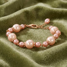 Pink pearl bracelet on a green fabric background