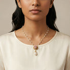Woman wearing a Pink Porcelain Rose Bud Faux Pearl Pendant Necklace against a neutral background