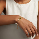 Close-up of a hand wearing a Bel Fiore Pink Glass Bead Faux Pearl Adjustable Bracelet
