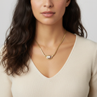 Woman wearing a gold necklace with a cameo pendant on a white background