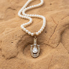 Ceremony 5mm Faux Pearl Strand Teardrop Crystal Pendant Necklace resting on sandstone surface
