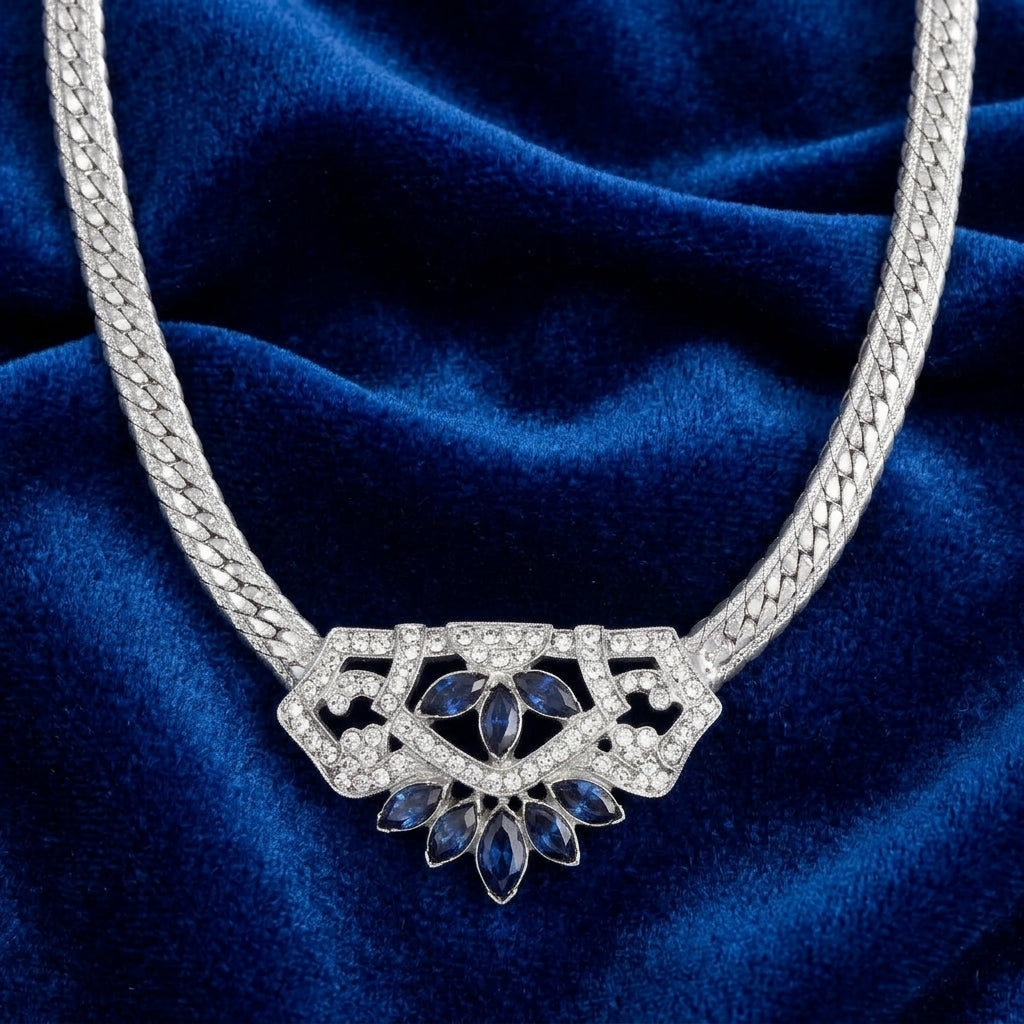 Genevieve Aura Dark Blue Crystal Pendant Necklace resting on dark blue fabric