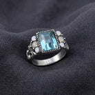 Aquamarine Crystal Rectangular Blue Crystal Opal Stone Ring resting on dark linen fabric
