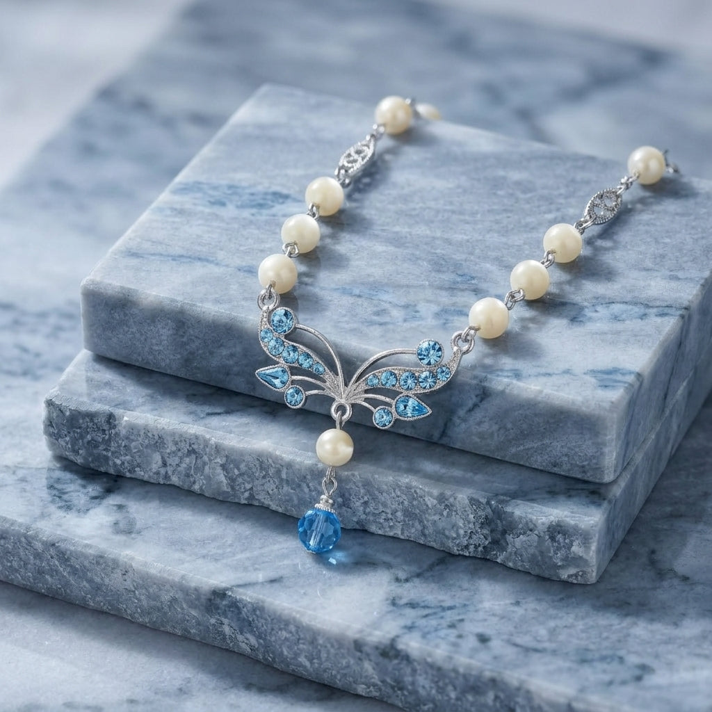 Aquamarine Crystal Mother Of Pearl Drop Necklace resting on blocks of blue marble stone