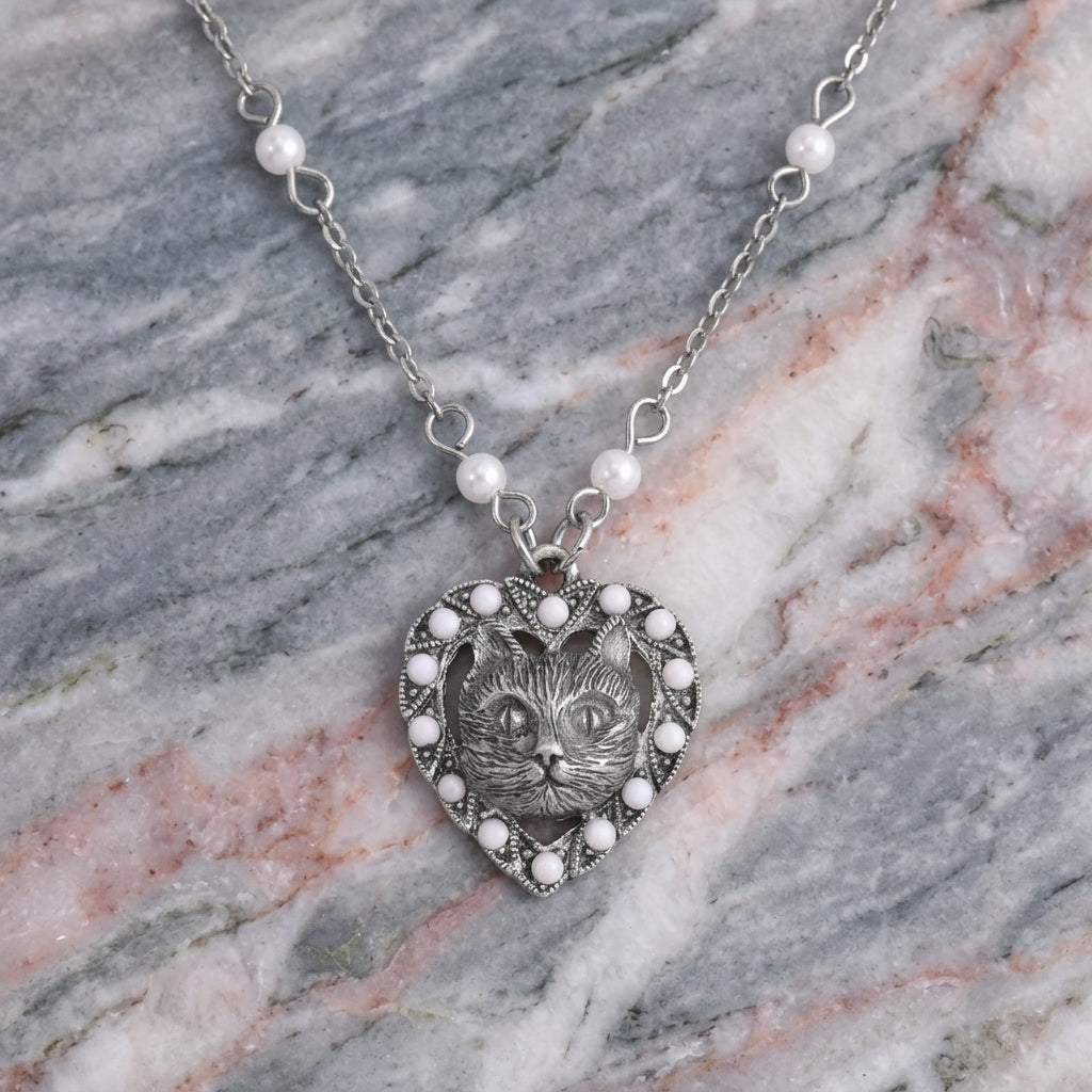 Heart And Cat Crystal Faux Pearl Pendant Necklace resting on stone surface