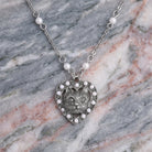 Heart And Cat Crystal Faux Pearl Pendant Necklace resting on stone surface