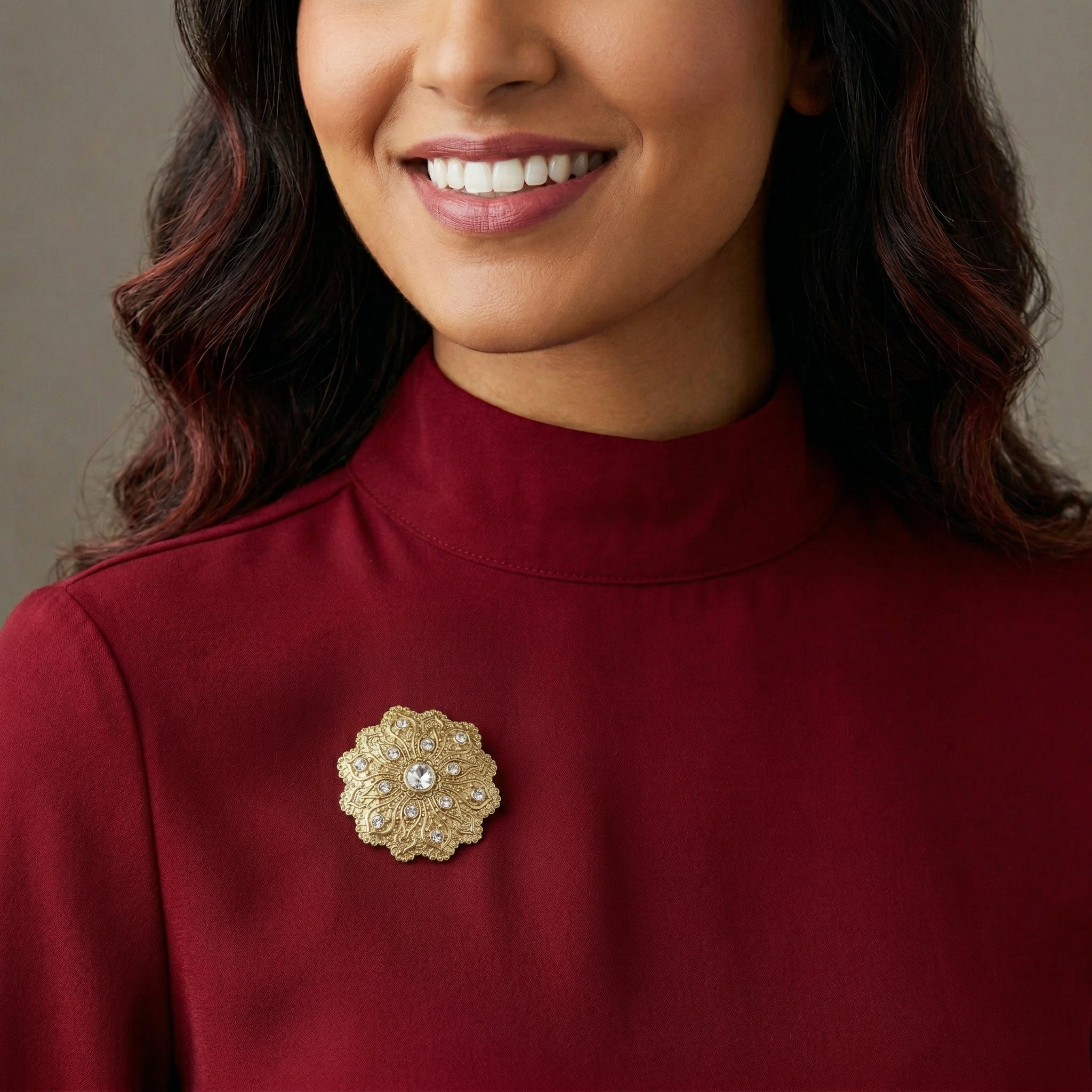 Woman in a red turtleneck wearing our gold tone Imperial Flower Crystal Brooch